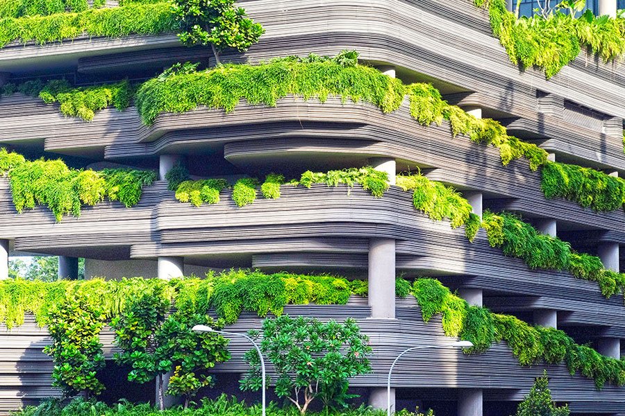 Modern building with layered terraces covered in lush green plants. Modern building with layered terraces covered in lush green plants.